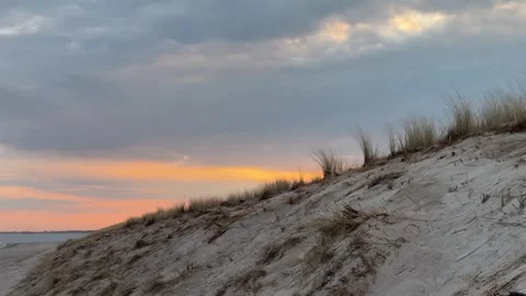 Sunrise over Graal-Mritz beach: sand dunes, beach grass, and cloudy sky. Stock Footage 319543437