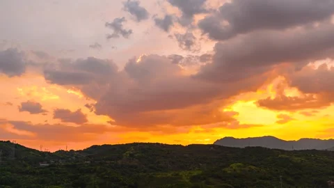 Sunrise Over Green Mountain Range with Dramatic Clouds and Golden Sky Stock Footage 341960723