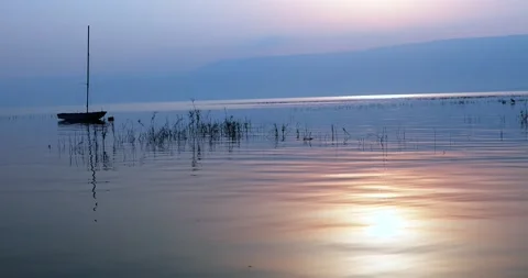 Sunrise over the lake. Boat floating on the calm water under amazing Sunrise. Stock Footage