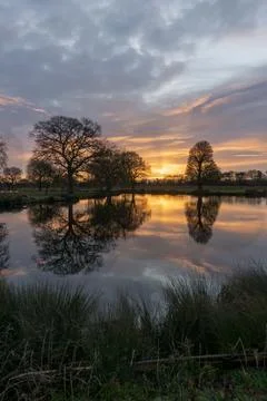 Sunrise over a lake with reflections Stock Photos
