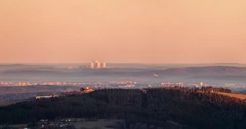 Sunrise over landscape - forest and hill with church, city and nuclear power Stock Photos
