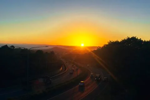 Sunrise Over Main Road with Mountains In Background Stock Photos