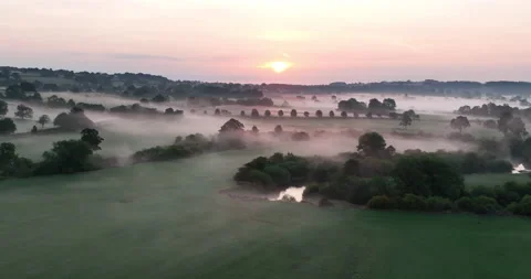 Sunrise over misty fields and still river Stock Footage 219974593