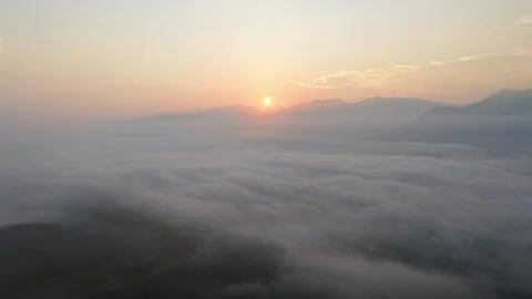 Sunrise over misty mountain landscape with soft clouds and warm sky Vídeos de archivo 344823404