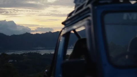 Sunrise over mountain range from blue off-road vehicle Stock Footage 302646095