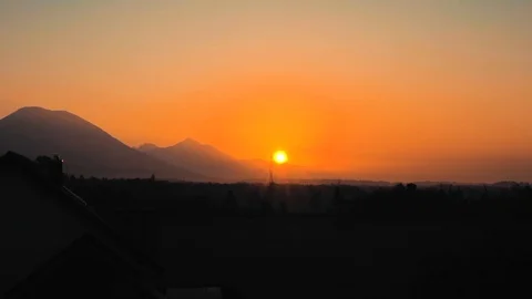 Sunrise over the mountain, trees, and power lines Stock Footage 106197859