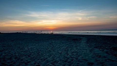 Sunrise over the ocean from beach in Ocean City, New Jersery with Atlantic City Stock Footage 92373151