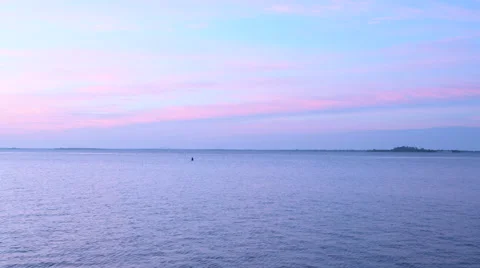 Sunrise over the ocean casting blue during the summer Stock Footage 64900440