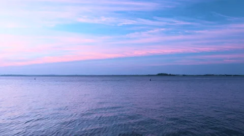 Sunrise over the ocean casting blue during the summer Stock Footage 64900691