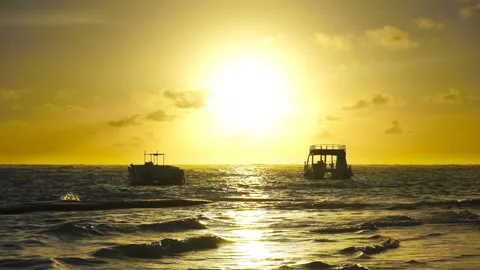 Sunrise over ocean waves. Two boats rock on the waves. Stock-Footage 86366928