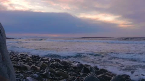 Sunrise over pebble beach at Cape Zemlyanov with gentle sea waves and pastel pin Stock Footage 308933877