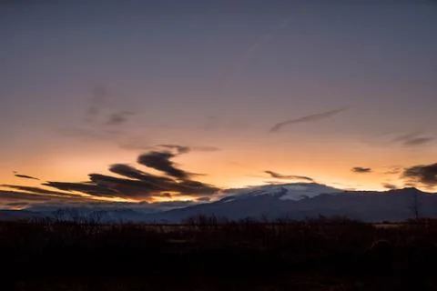 Sunrise over a resting volcano with cloud stacks Stock Photos