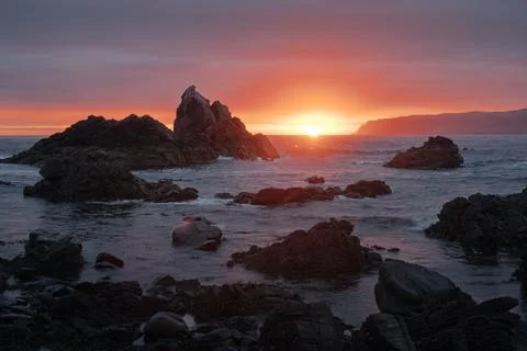Sunrise over the seashore with cliffs Stock Photos