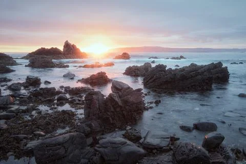 Sunrise over the seashore with cliffs Stock Photos