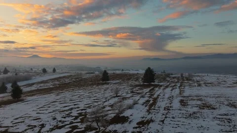 Sunrise Over Snow-Patched Fields and Misty Mountains in Romania Stock Footage 332313861