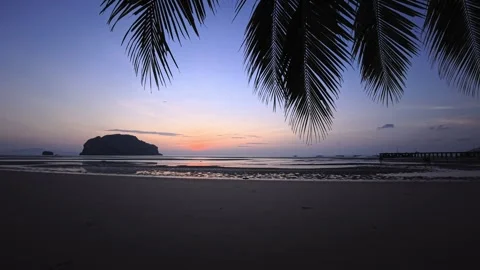 Sunrise over tropical beach at low tide with island silhouette and turquoise sea Stock Footage 332763788