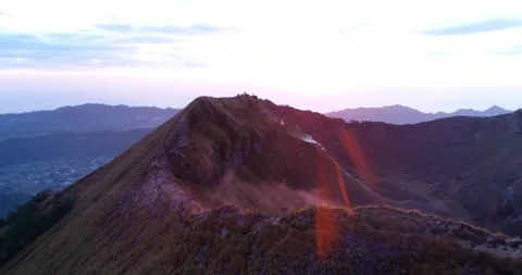 Sunrise over volcano with clouds on top and lake at the bottom Stock Footage 114589313
