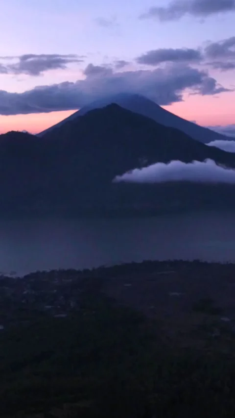 Sunrise over volcano with clouds on top and lake at the bottom Stock-Footage 228012318