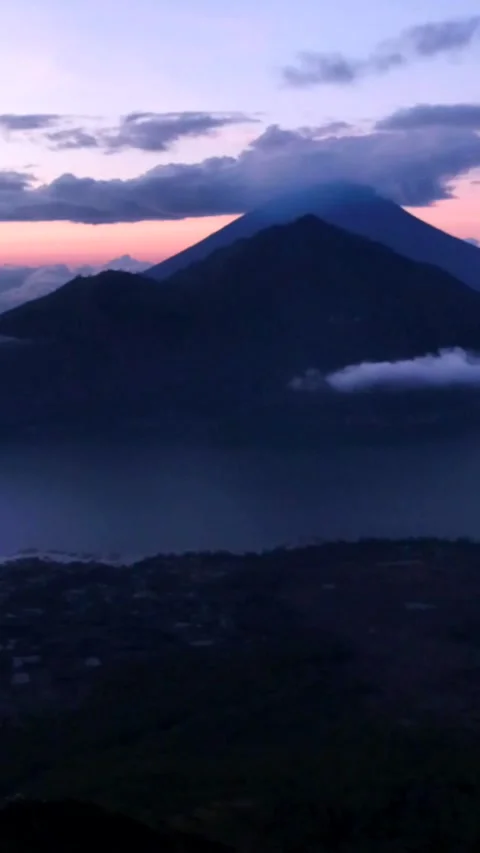 Sunrise over volcano with clouds on top and lake at the bottom Stock Footage 230289767