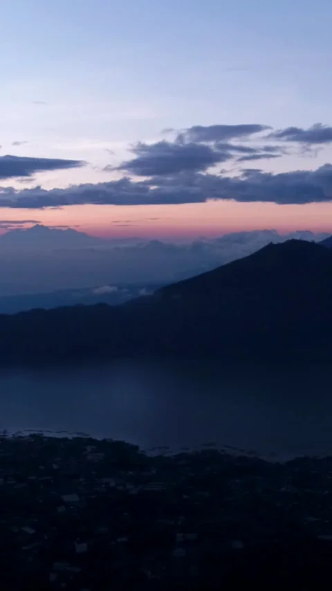 Sunrise over volcano with clouds on top and lake at the bottom Stock Footage 230289773