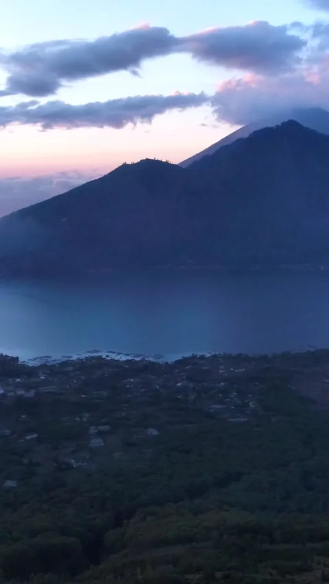 Sunrise over volcano with clouds on top and lake at the bottom Video stock 230291085