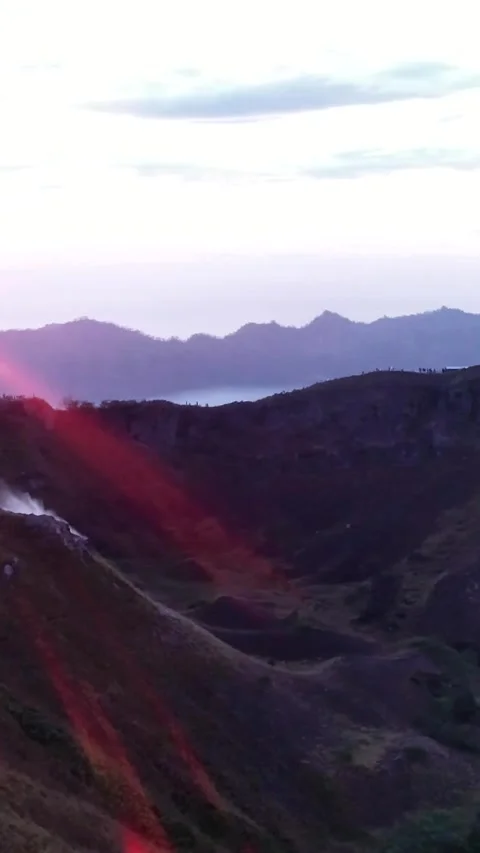 Sunrise over volcano with clouds on top and lake at the bottom Video stock 230291092