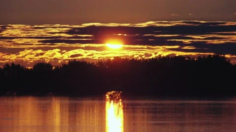 Sunrise passing behind cloud at the river Stock Footage 130863724