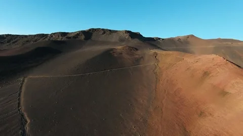 Sunrise on path crossing a desert of ashes in volcano caldera, Hawaii 4K aerial  Video stock 196907694