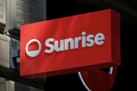 Sunrise red light box logo sign on store entrance facade in Switzerland Фото