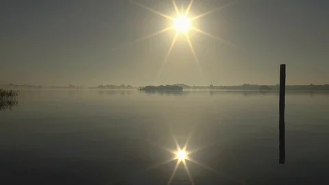 Sunrise Reflected in Calm Surface of a Lake Stockbeeldmateriaal 86289704