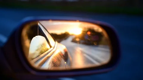 Sunrise reflected in car wing mirror on country road uk Stock Footage 120559724