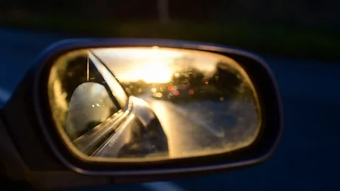 Sunrise reflected in car wing mirror on country road uk Stock Footage 120560661