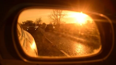 Sunrise reflected in car wing mirror on country road uk Stock Footage 120778551