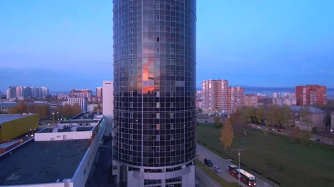 The sunrise is reflected in the glass wall of a skyscraper in a modern city. Stock Footage 131767219