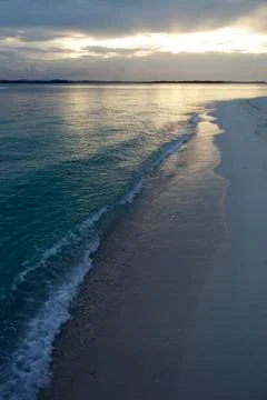 Sunrise reflecting on empty beach Stock Photos