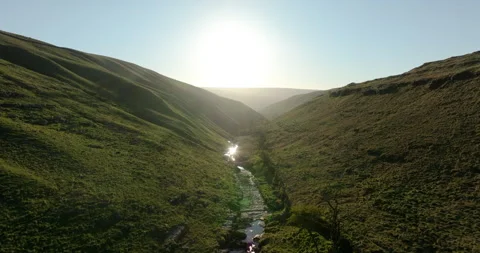 Sunrise reflecting on a river in the bottom of a valley Stock Footage 335337038