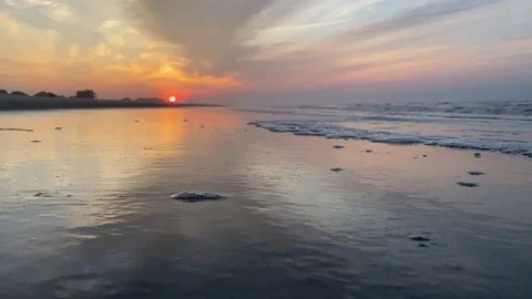 The sunrise rises while waves splash up onto shore Vídeos de archivo 219325276