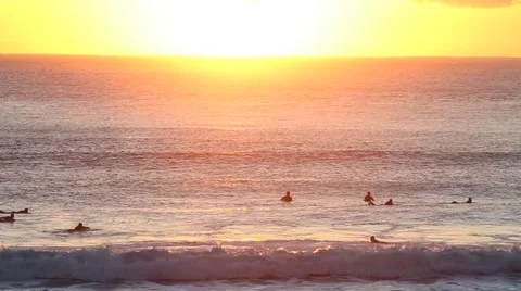 Sunrise on sea with surfers Stock Footage