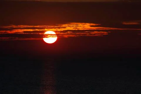 Sunrise. A sun disk pierced by clouds Stock Photos