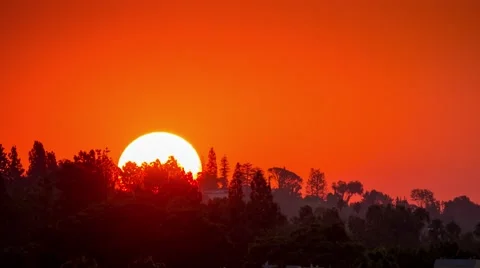 Sunrise sun orange sky rising above Hollywood Hills Los Angeles California Stock Footage