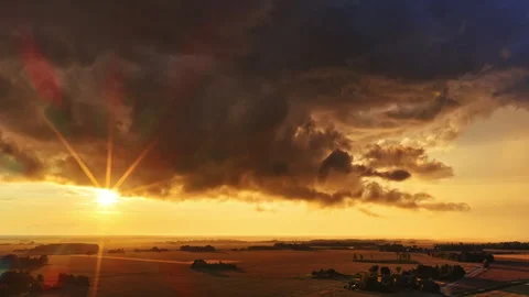 Sunrise sun rays from thick layer of rain clouds, low level gray color over Stock Footage 321348245