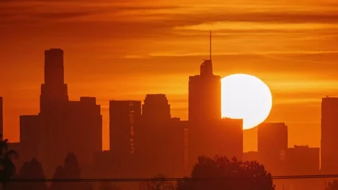 Sunrise sun rising over downtown Los Angeles skyscrapers, zoom out city skyline Stock Footage