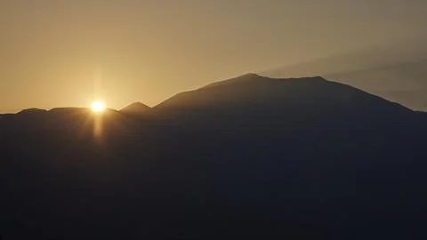 Sunrise sun solidifies behind the double peak of Psiloritis Meronas Central Stock Photos