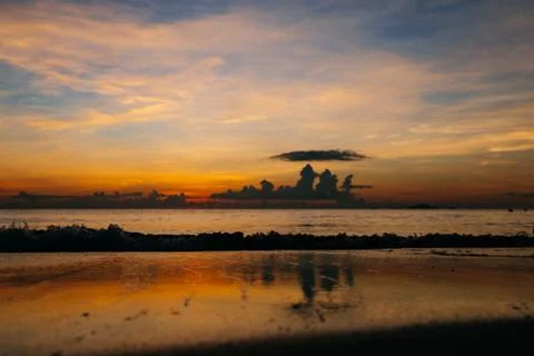 Sunrise, sunset of the sun through the clouds, tropical area near  sea. Stock Photos