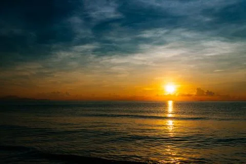 Sunrise, sunset of the sun through the clouds, tropical area near  sea Stock Photos