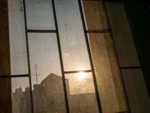 Sunrise Through Dusty Window Screen with Rooftop Silhouette, Urban Morning .. 스톡 사진