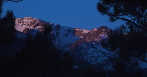 Sunrise through the trees looking to McHenry's Peak in Colorado Stock-Footage 170592099