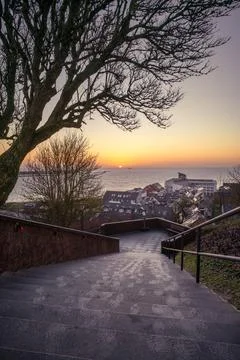 Sunrise through under the tree and above small port city of Helgoland, Germany Stock Photos