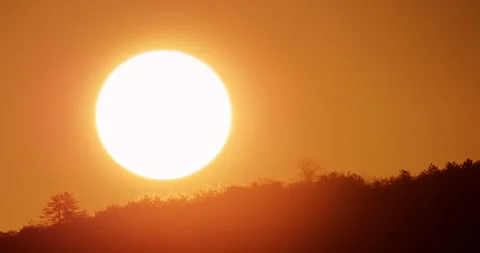 Sunrise time lapse, massive orange sun rising over dark mountain forest trees 4K Video stock 320818952