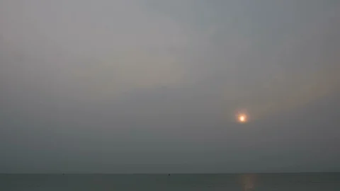 Sunrise time lapse over the ocean on a foggy and overcast morning Stock Footage 105550661